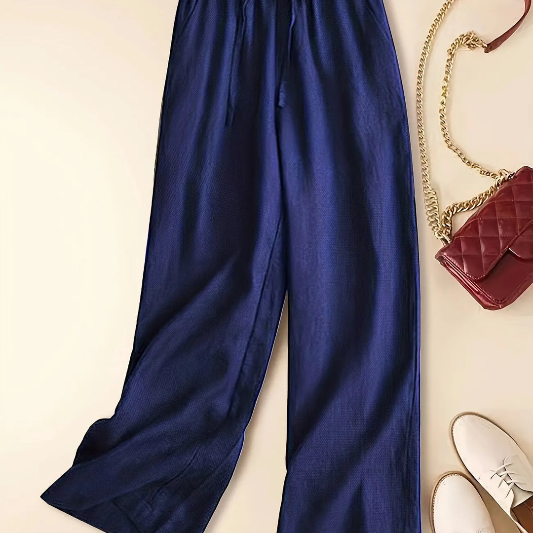 Female model wearing easy-fit drawstring pants on a clean plain background.