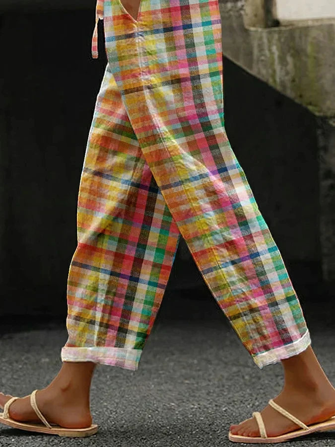 Woman in stylish checkered trousers on a clean background.