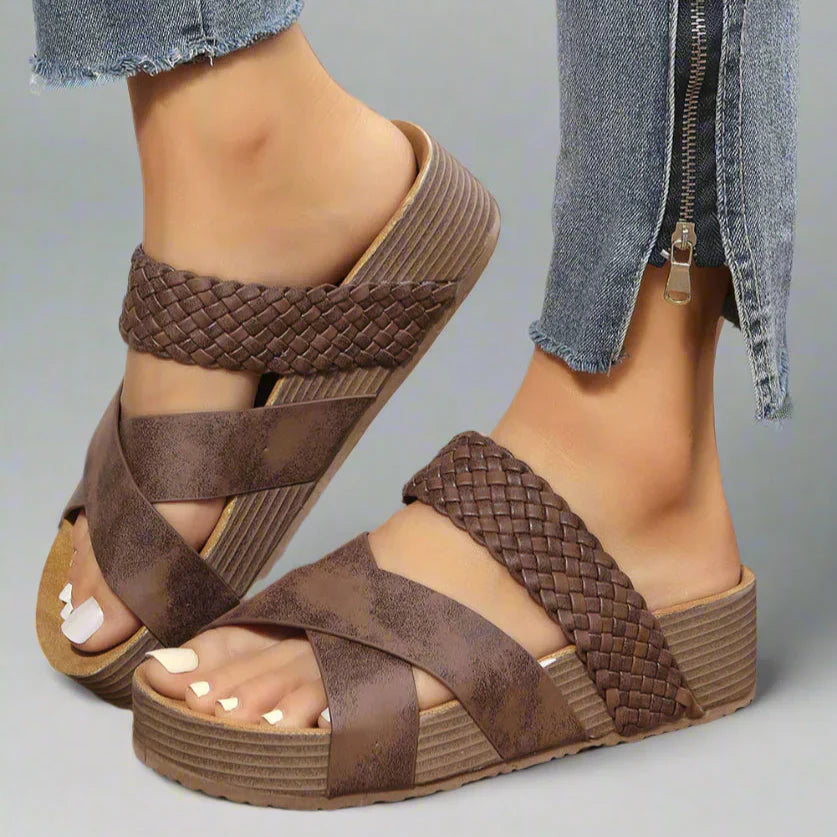 Foot wearing orthopedic sandal on a plain background.