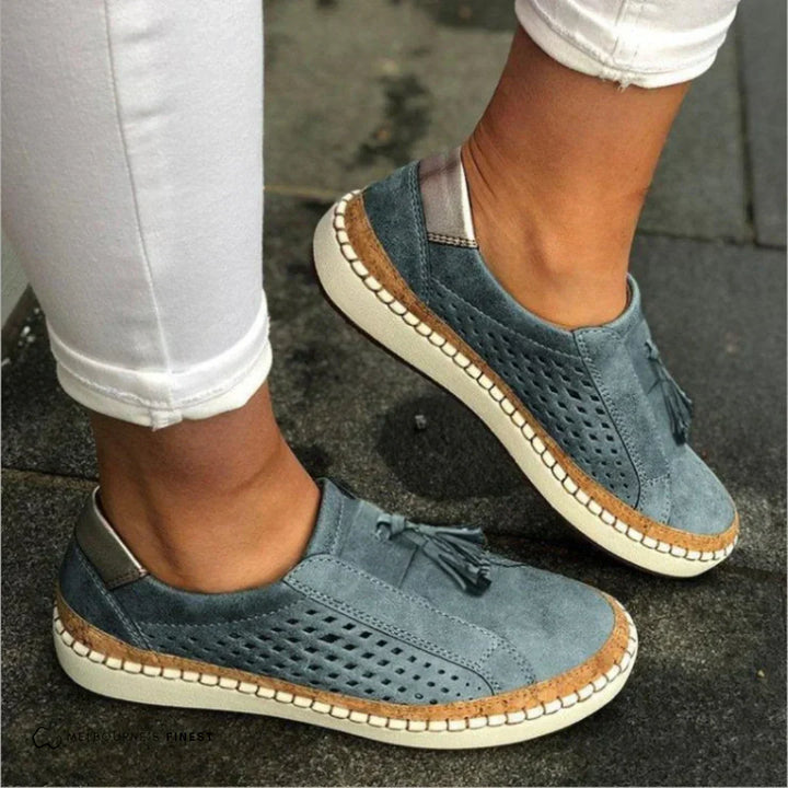 Female model showcasing casual slip-on sneakers against a plain background.
