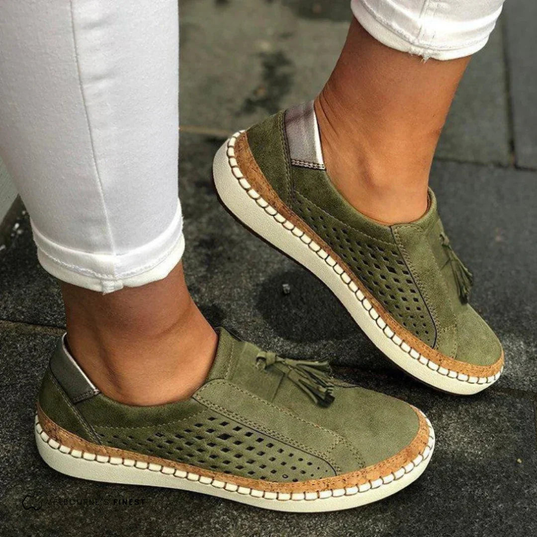 Woman wearing slip-on sneakers on a plain background for a clean everyday footwear look.
