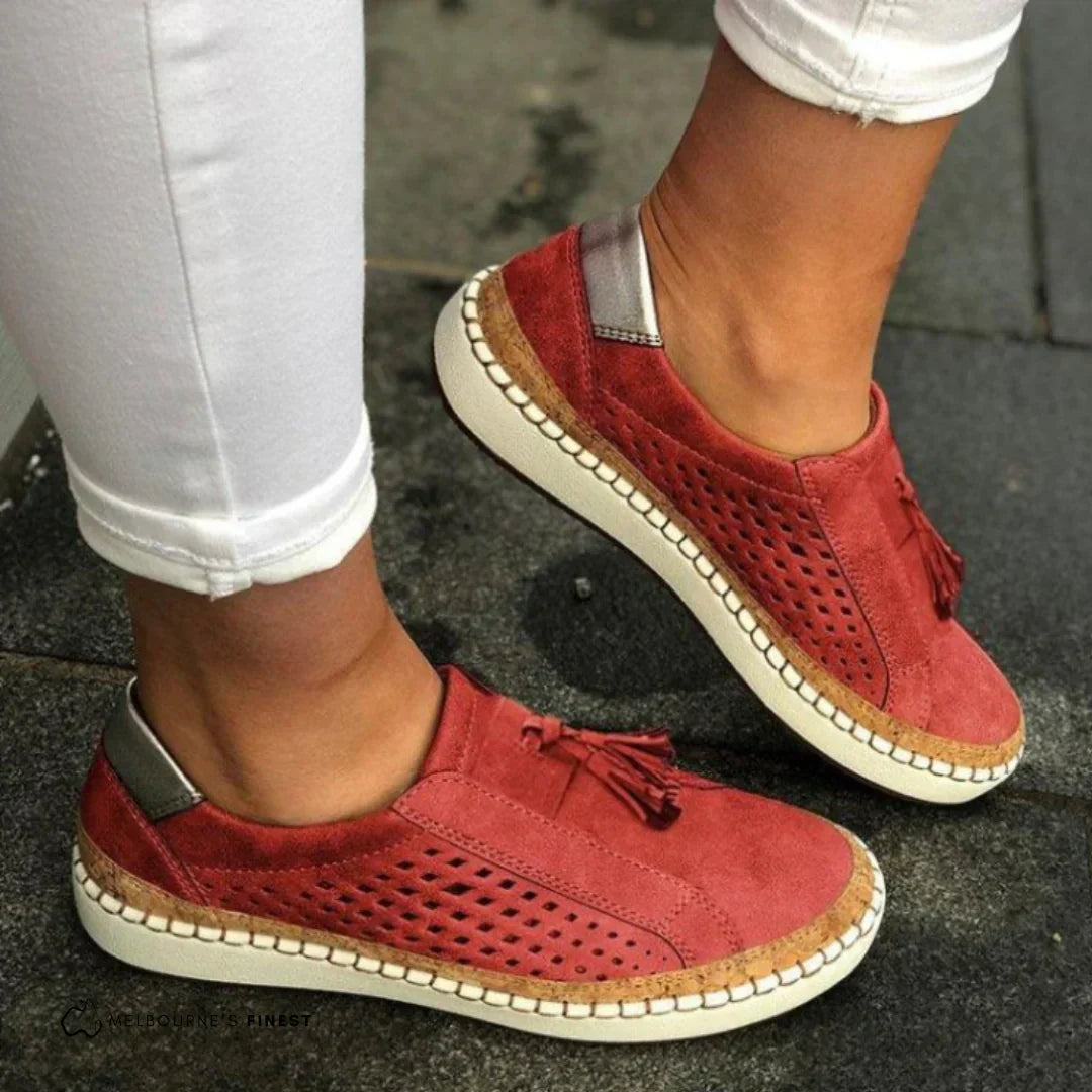 Female model wearing modern casual sneakers with a simple plain backdrop.