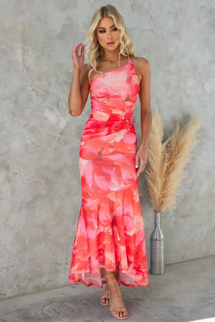 Female model in a breezy floral dress on a clean background.