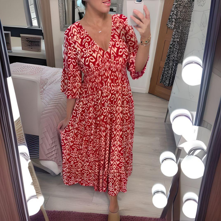 Woman wearing a boho print round neck dress on a bedroom background.