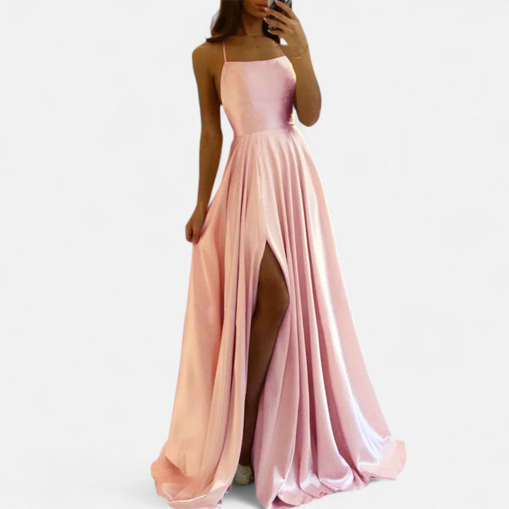 Female model in wedding guest dress, standing on white background.