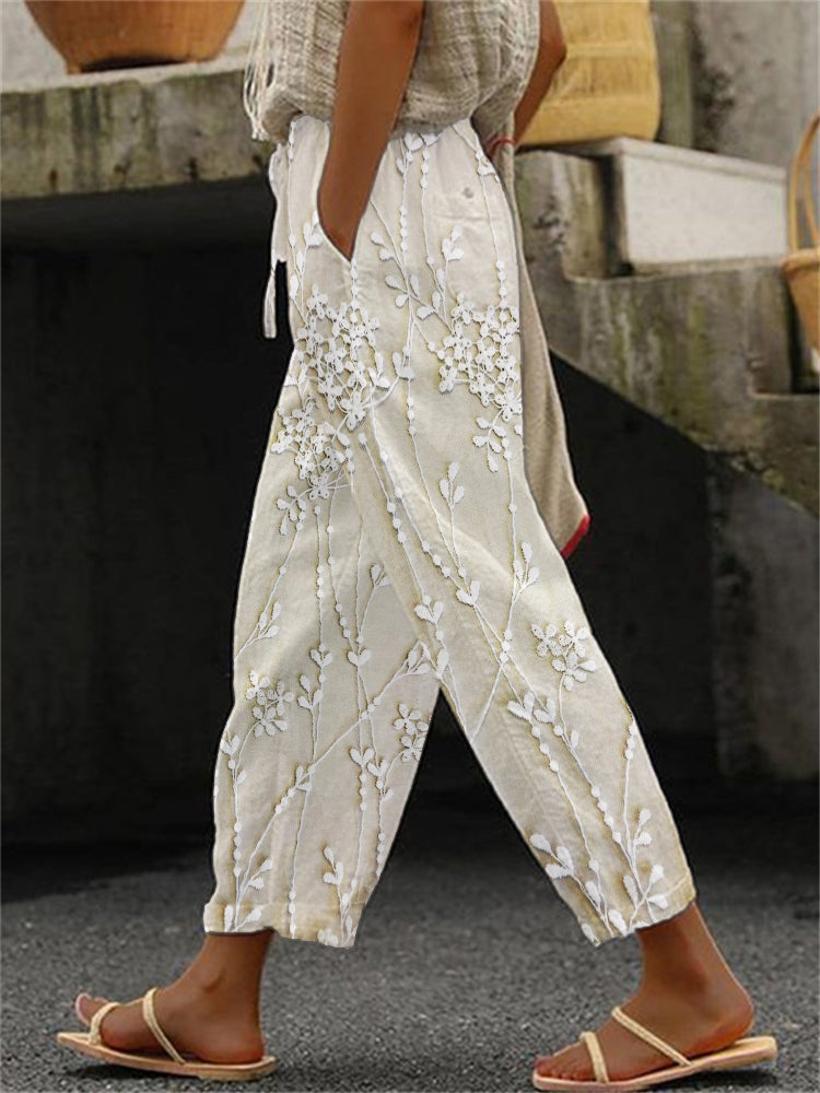 Woman wearing bold printed trousers against a plain background.
