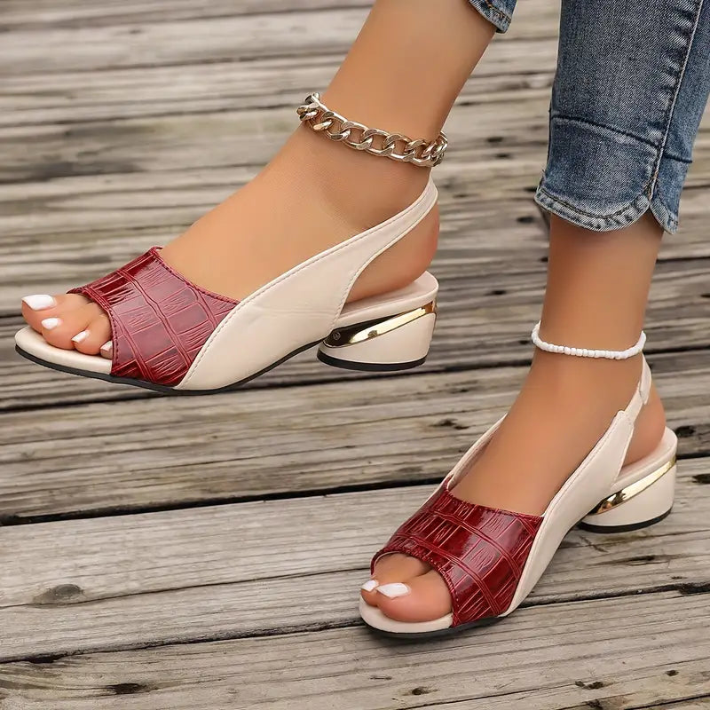 Close-up of foot in chic open-toe sandal on a plain background.