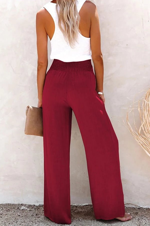 High-waisted trousers for women styled with a clean plain backdrop.