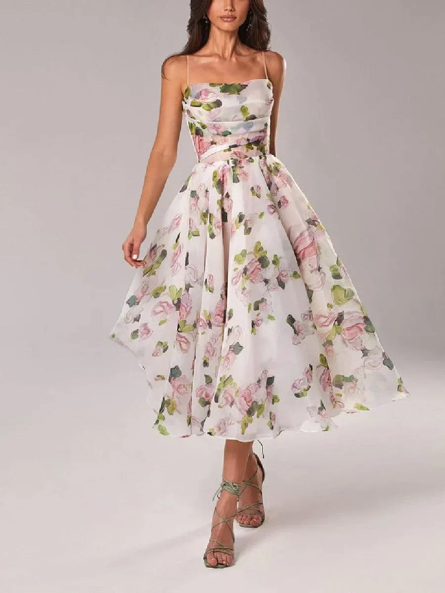 Female model wearing a floral print strapless midi dress with a fitted bodice and flowing full skirt against a plain background.