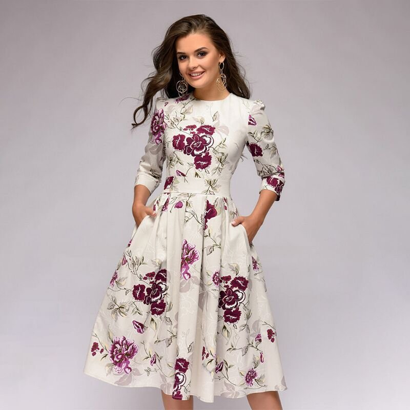 Model wearing a knee-length floral print dress against a plain background.