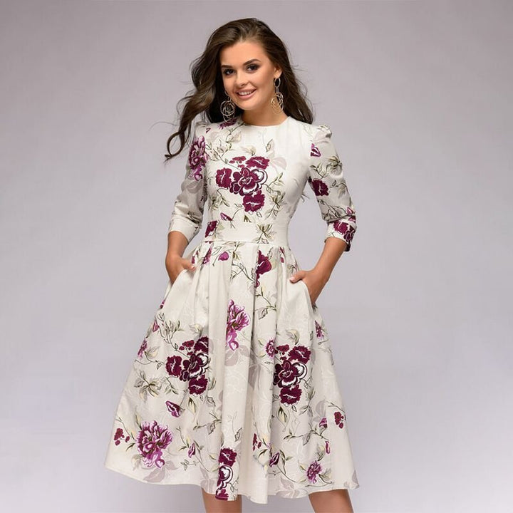 Model wearing a knee-length floral print dress against a plain background.