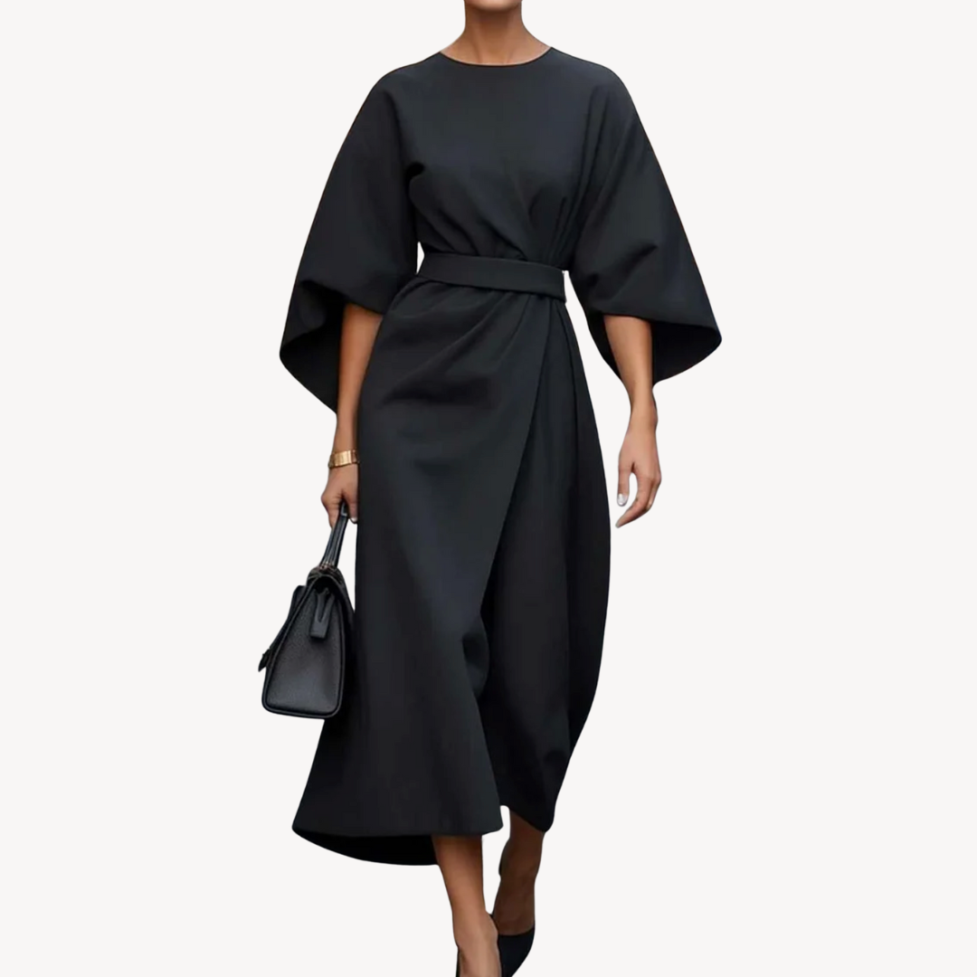 Female model wearing a belted midi dress with wide sleeves on a plain background.