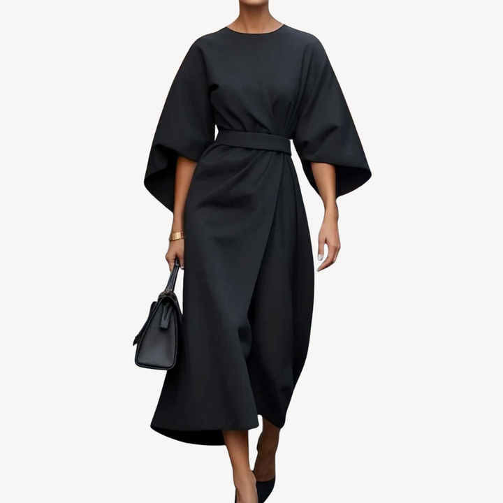 Female model wearing a belted midi dress with wide sleeves on a plain background.
