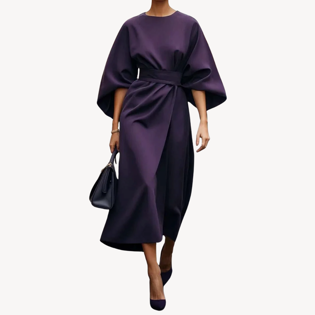 Model displaying a refined belted midi dress against a plain background.