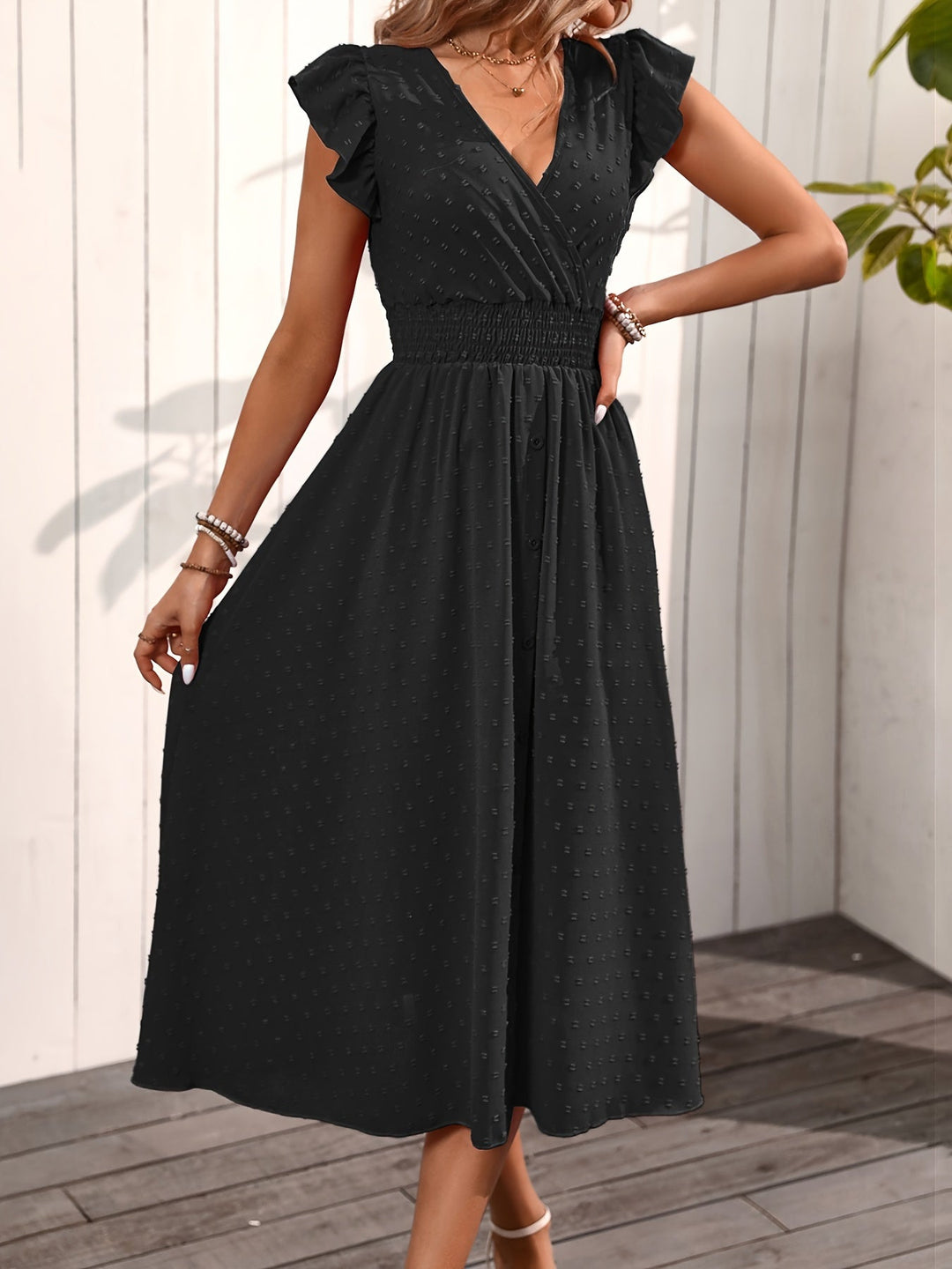 Model wearing a button-down midi dress with smocked waist and ruffle sleeves in nature.