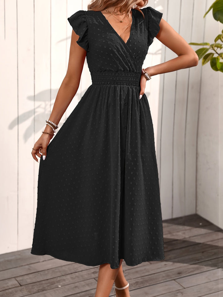 Model wearing a button-down midi dress with smocked waist and ruffle sleeves in nature.