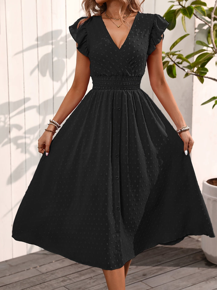 Model wearing a stylish button-front midi dress with dotted pattern and nature backdrop.