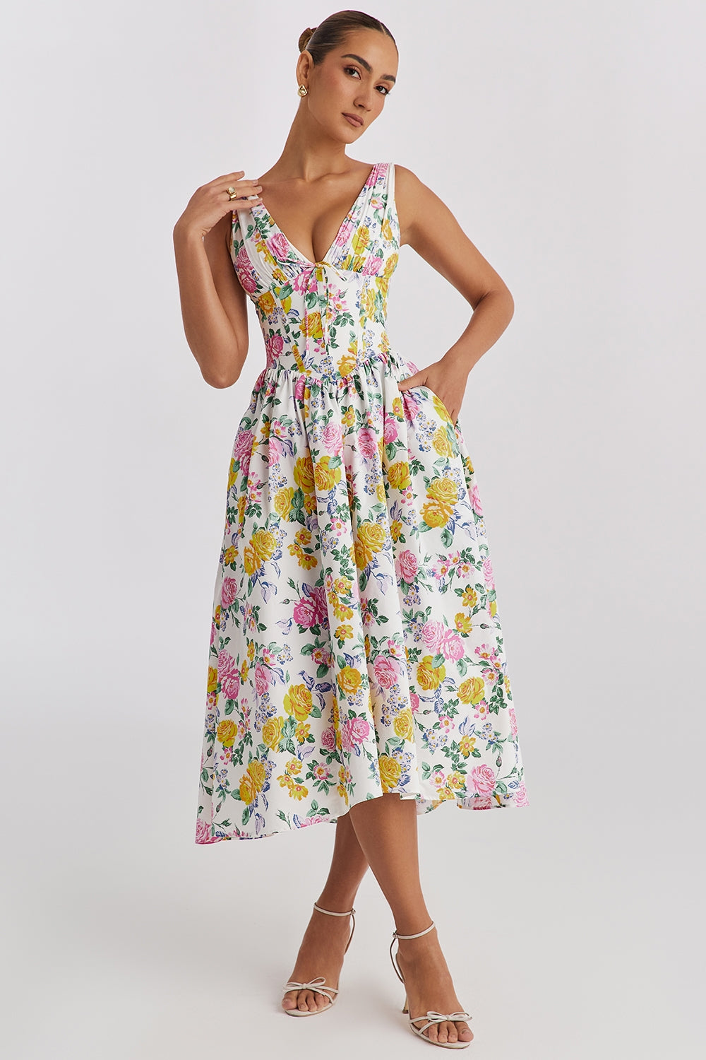 Woman wearing a flowy summer dress on a plain background.