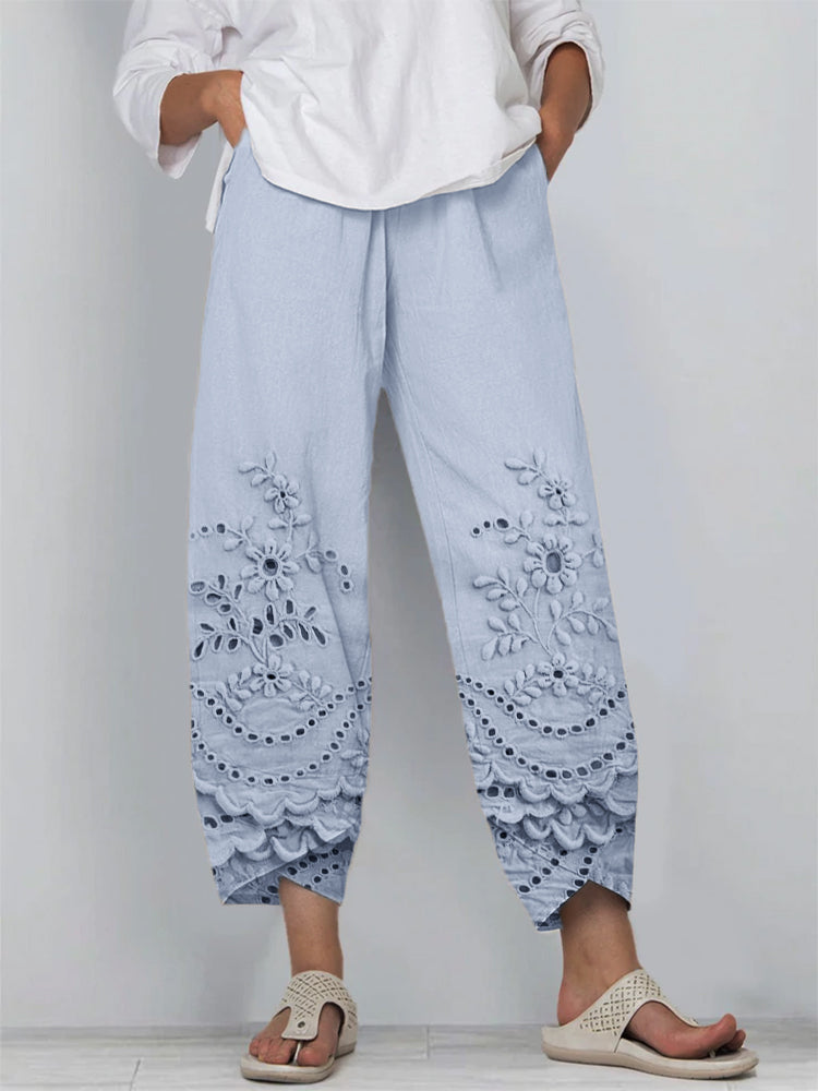 Woman wearing elegant trousers against a plain background.
