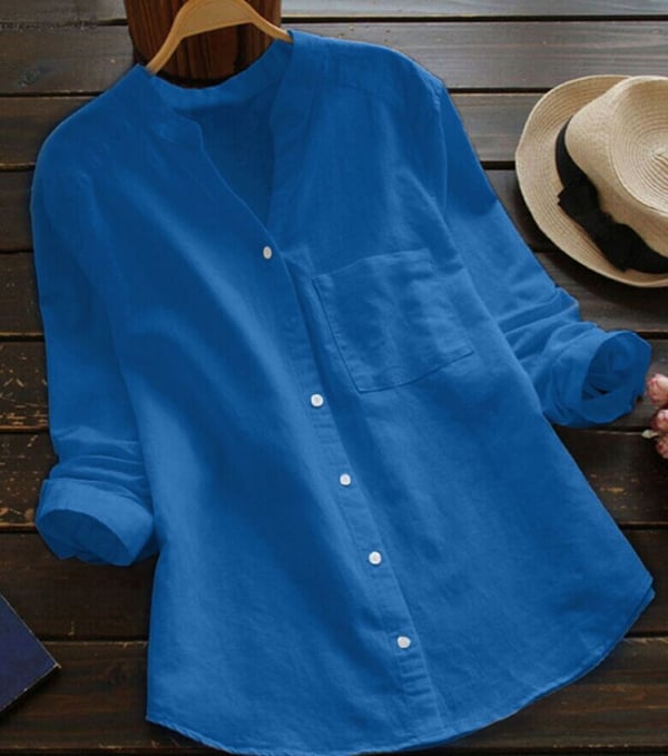 Casual airy shirt laid flat with hanger on plain studio wooden background