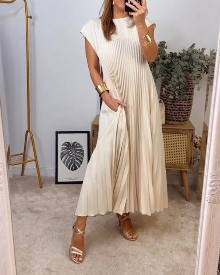 Female model wearing a pleated maxi dress with elegant movement.