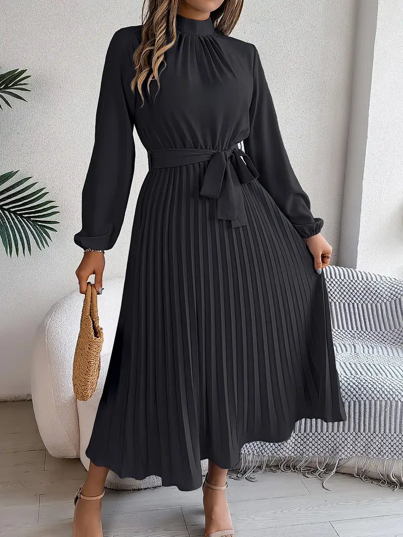 Female model wearing a long belted dress for formal occasions on a plain background.