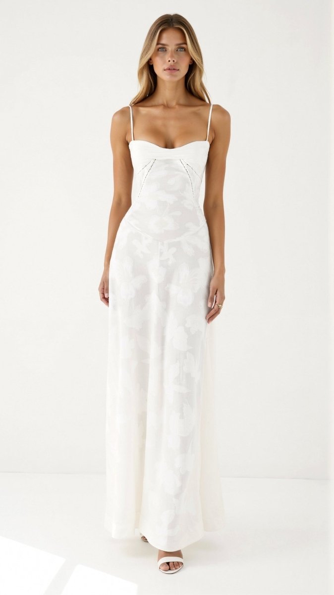 Female wearing a long floral dress with a refined and feminine silhouette against a plain background.