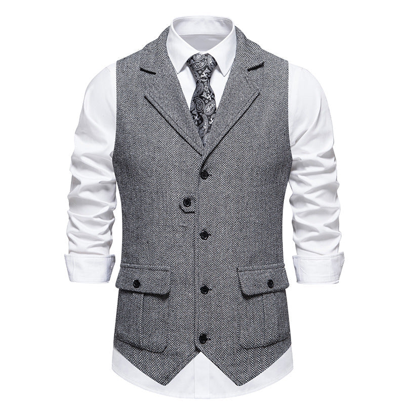 Displaying sharp tailored vest in studio, plain gray background.