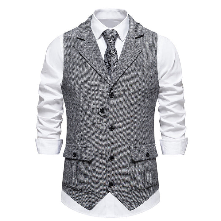 Displaying sharp tailored vest in studio, plain gray background.