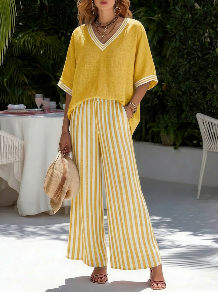  Female model showcasing a striped two-piece outfit with a relaxed wide leg shape on a plain background.