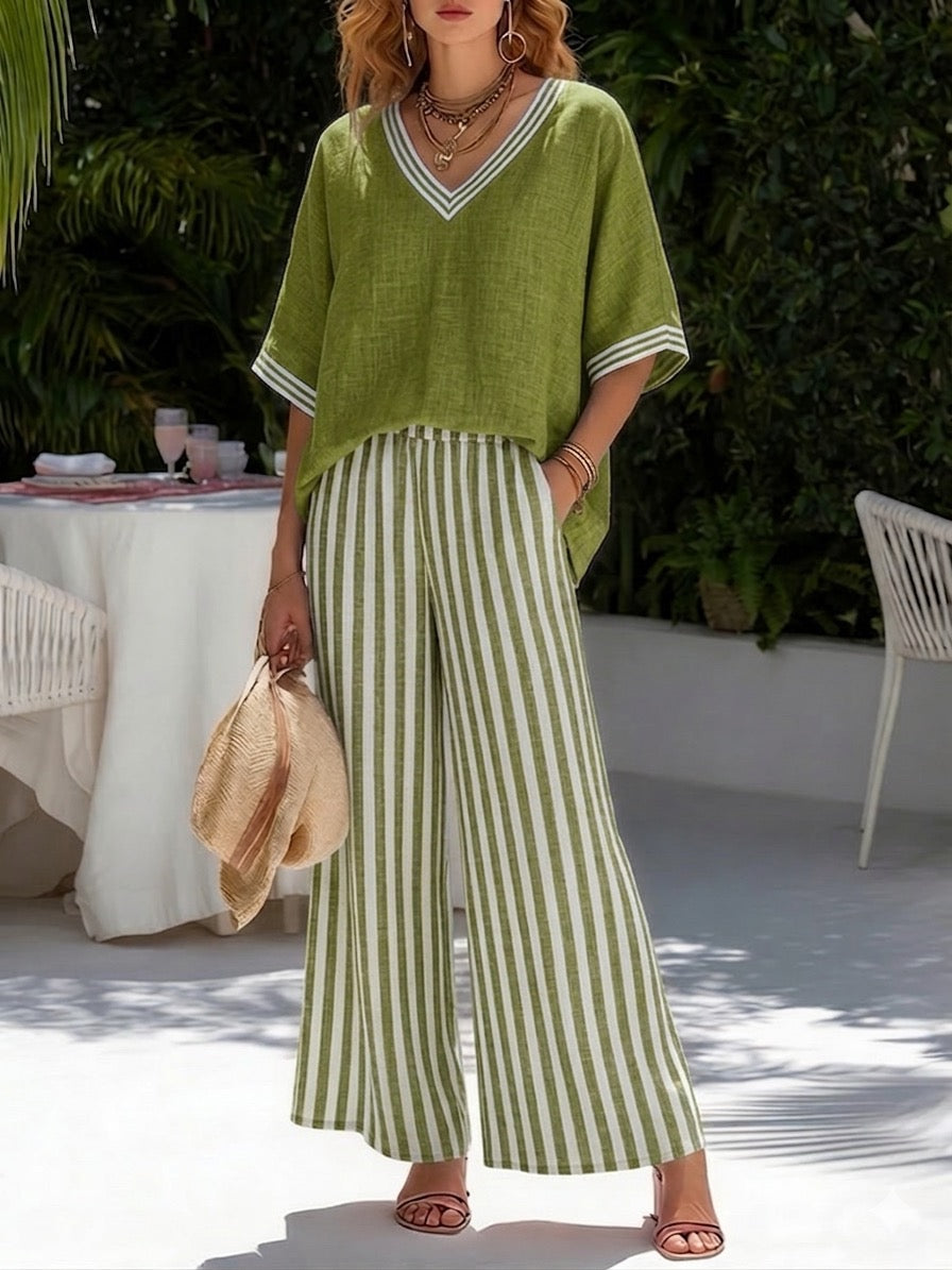 Model wearing a striped V-neck sleeveless top with flowing wide leg pants on a plain background.