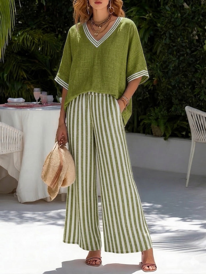  Model wearing a striped V-neck sleeveless top with flowing wide leg pants on a plain background.