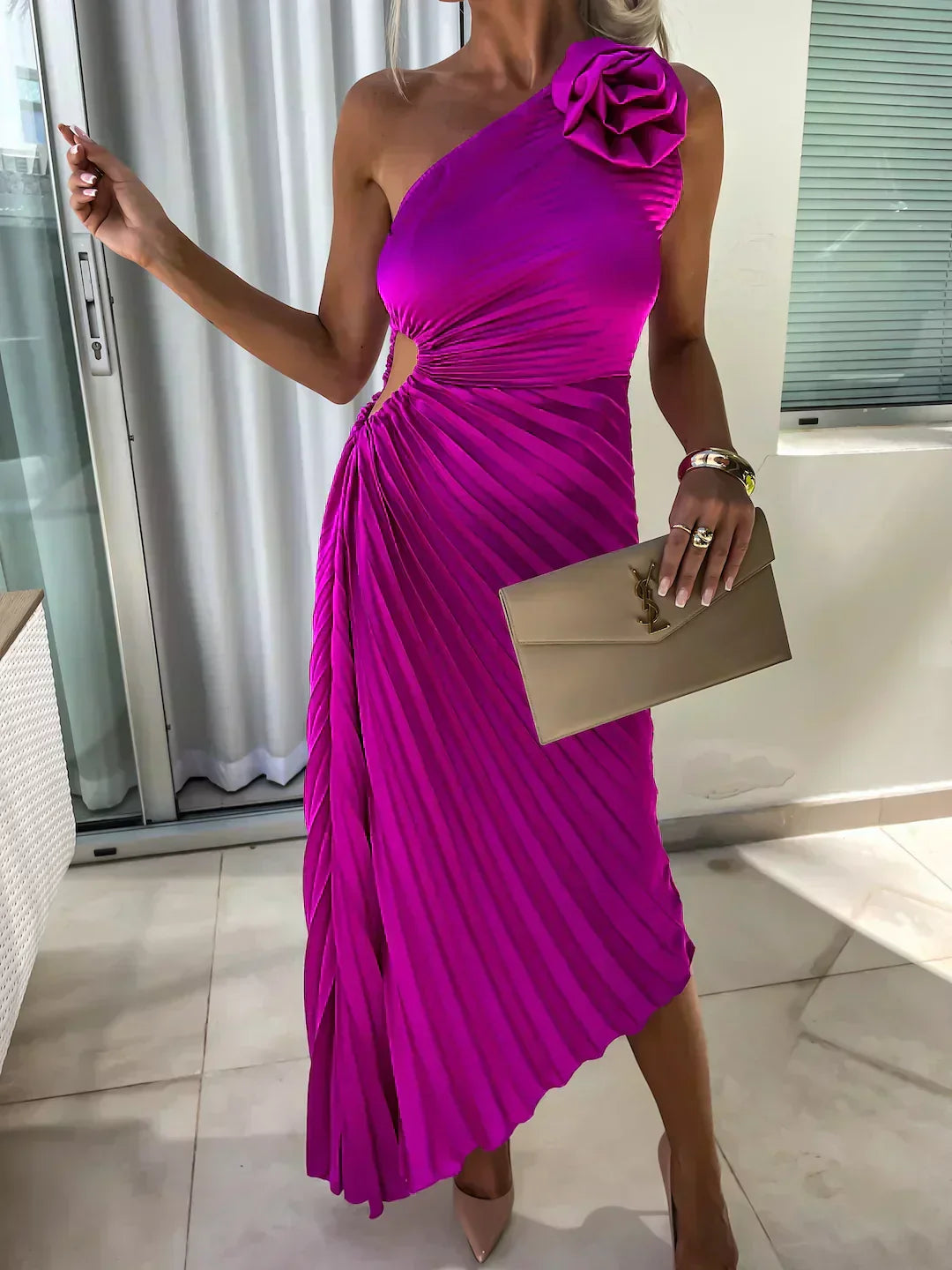Woman posing in a romantic floral midi dress on a plain backdrop.