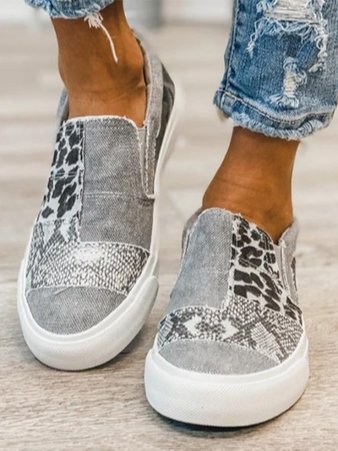 Female feet modeling lightweight slip-ons against a minimal plain background.
