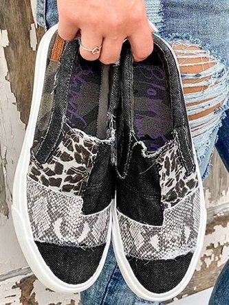 Female feet in casual travel shoes displayed on a plain studio background.