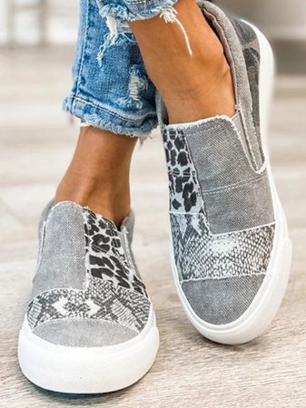 Female model showing side view of walking slip-ons on a plain backdrop.