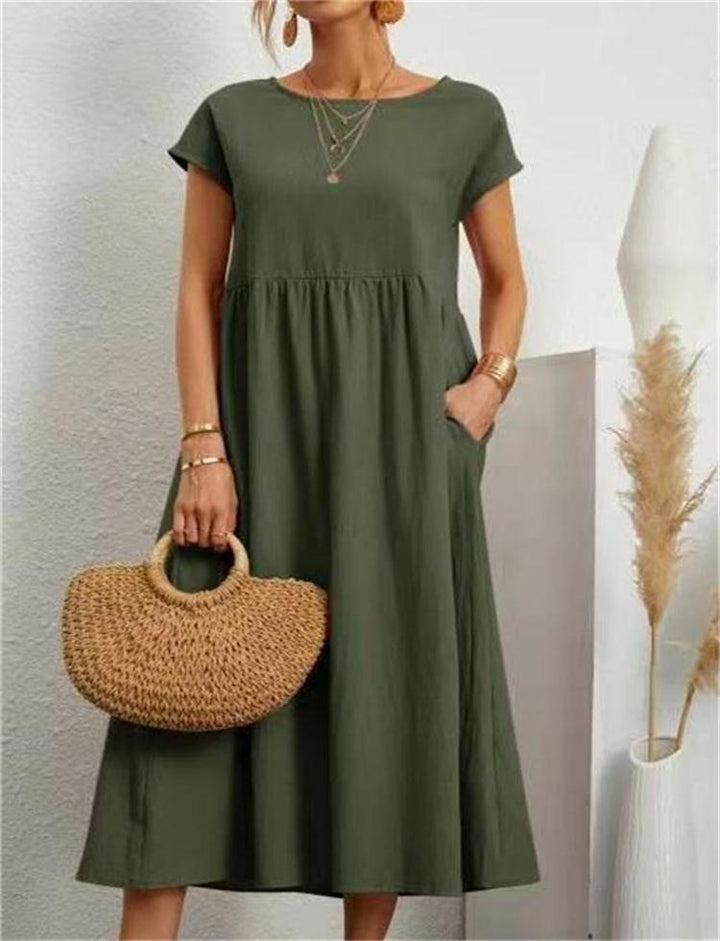 Female model displaying a chic maxi dress with a flowing silhouette on a plain background.