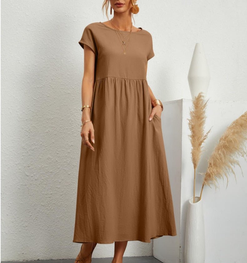  Woman wearing a long fashion dress with a minimalist design on a plain background.