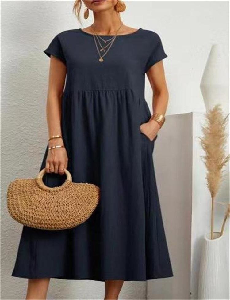 Woman showcasing a relaxed-fit maxi dress with a modern appearance on a plain background.