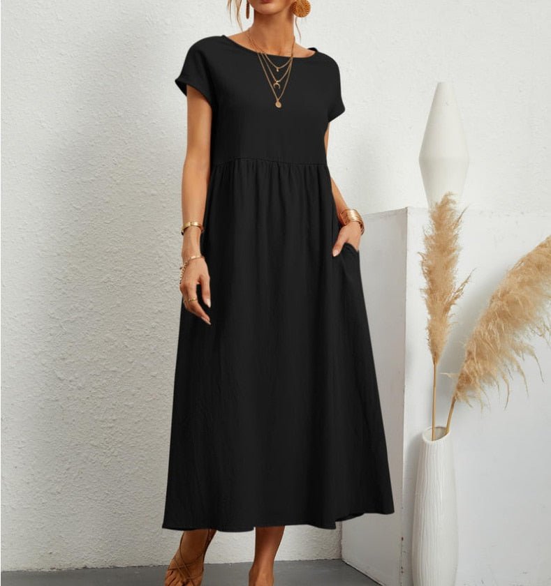 Female model wearing a flowing solid-color maxi dress against a plain background.