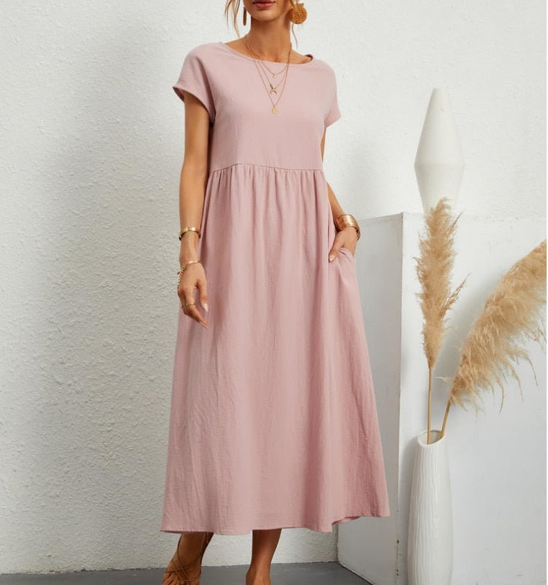  Female model displaying a long solid-color dress with a flattering drape on a plain background.