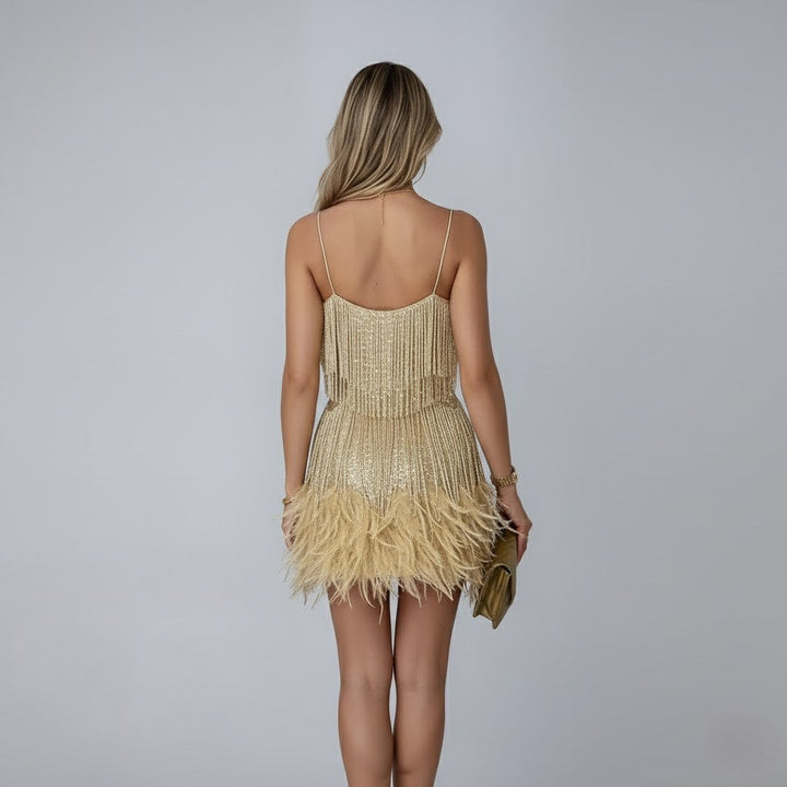 Female model in a celebration mini dress with textured feather trim on a plain background, back view