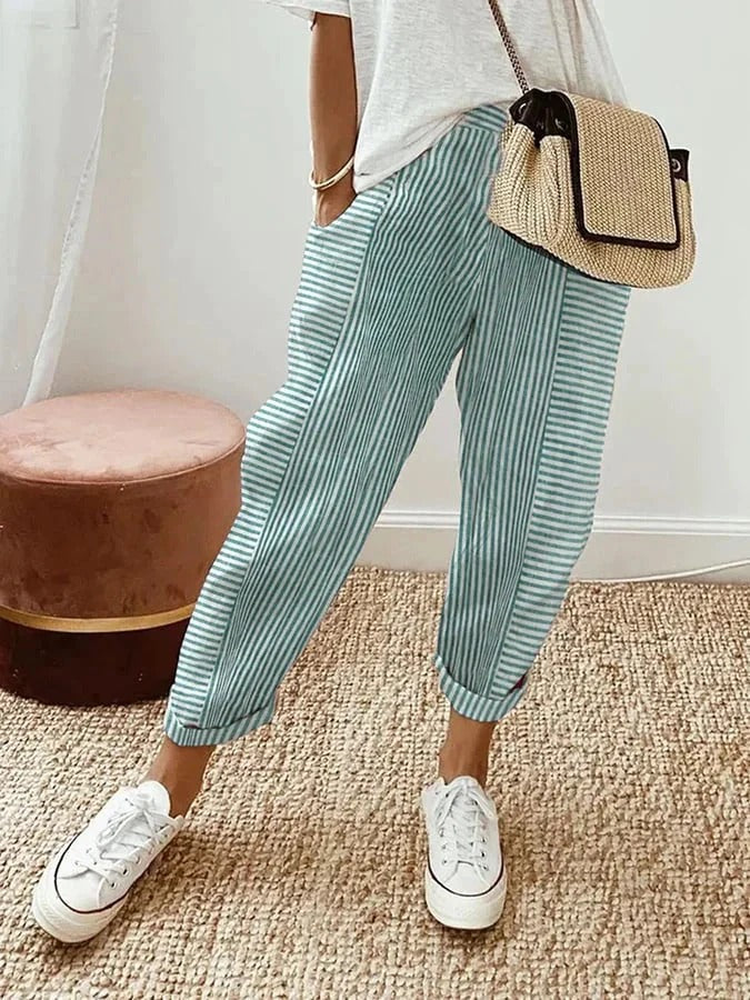Model showcasing relaxed striped trousers on a plain background.