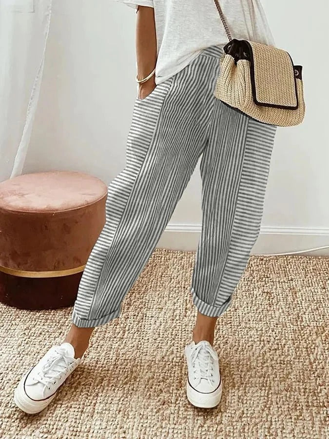 Female model wearing flowy striped pants with a polished look.