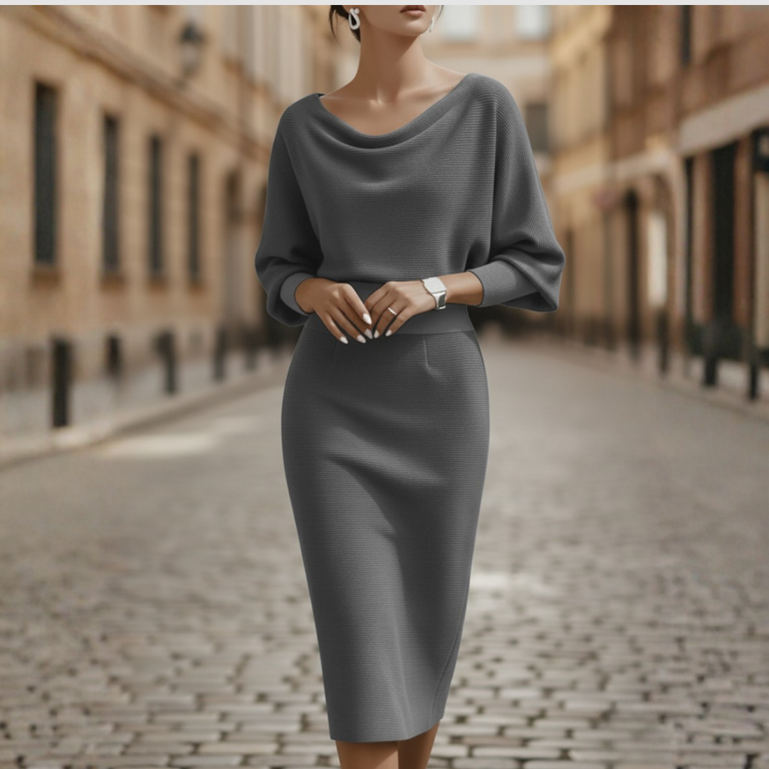 Female wearing a cowl neck midi dress with batwing sleeves and fitted pencil skirt on a plain background.