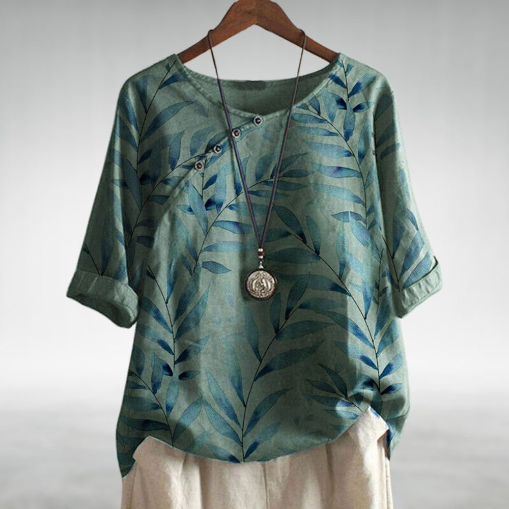 Stylish women’s blouse displayed on a plain background with playful accents and a soft flattering fit.
