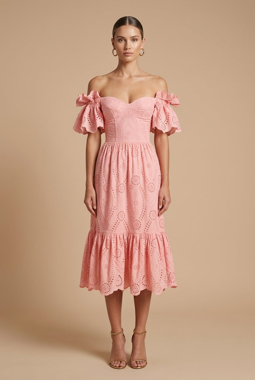 Female model wearing a structured dress with button details against a plain background.