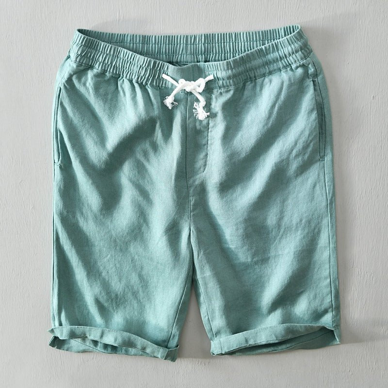 Male model wearing drawstring Bermuda shorts on a plain background.
