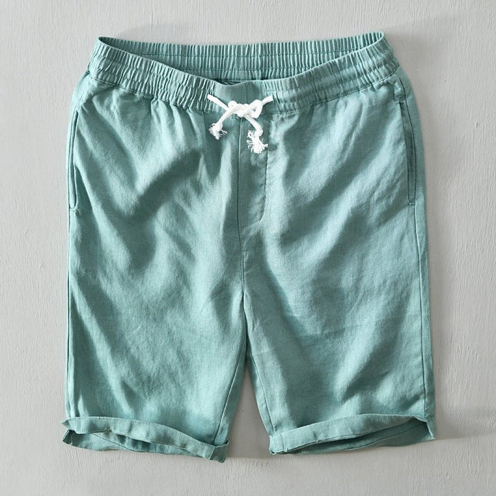 Male model wearing drawstring Bermuda shorts on a plain background.