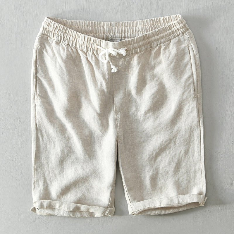 Male model standing in relaxed-fit summer shorts on a plain background.